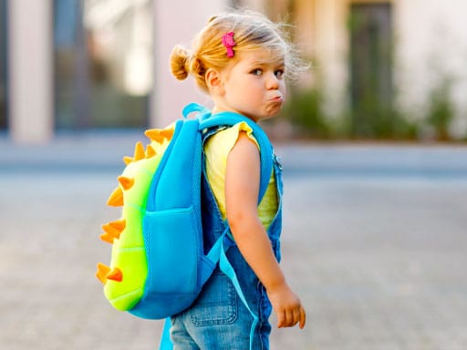 Child With Schoolbag Looking Backwards