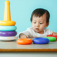 A Boy Playing With Toys As A Way To Learn