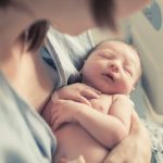 Mother Cradling Newborn In The Hospital