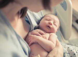 Mother Cradling Newborn In The Hospital