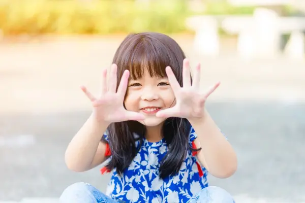 A little girl shows her hands while learning about hygiene practices