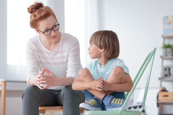 A child talking to a psychologist as part of psychological therapy